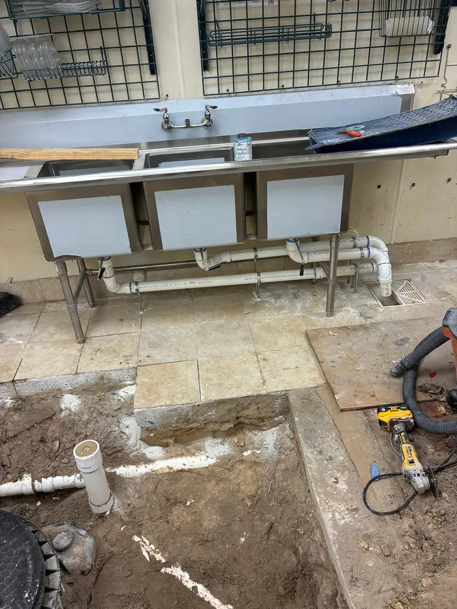 Commercial three-compartment sink drain rough-in in progress