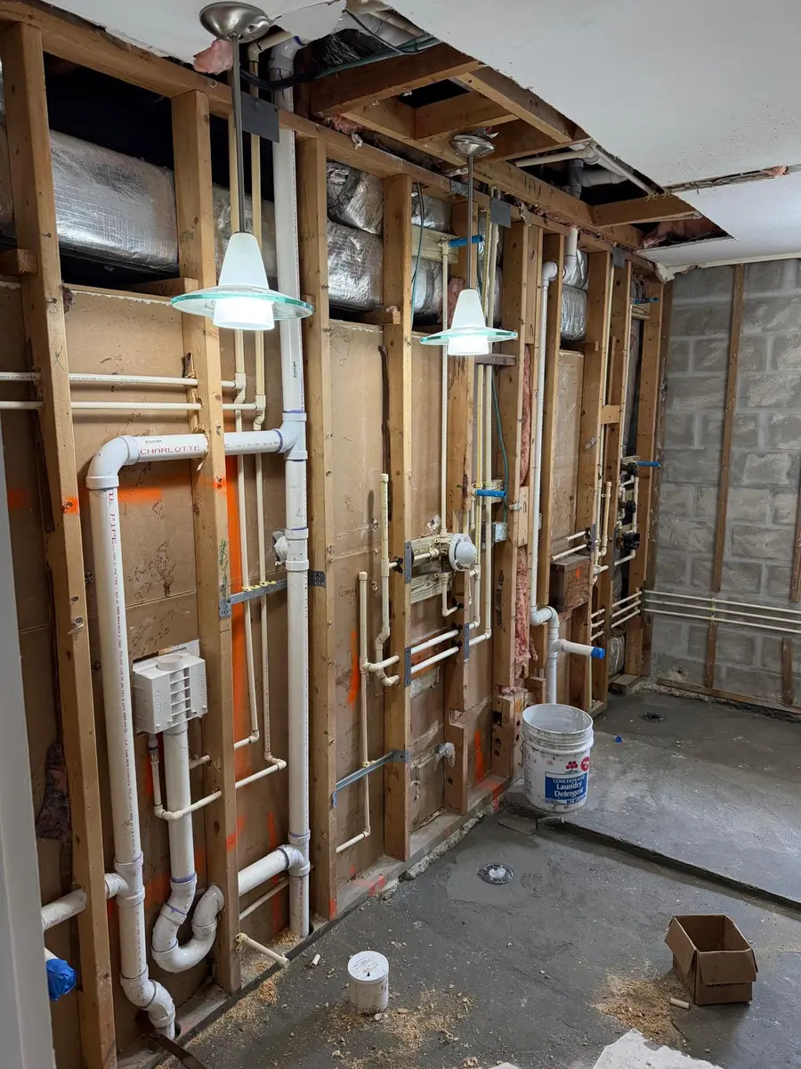 Copper water lines and drain stacks roughed into framed walls on a new construction project